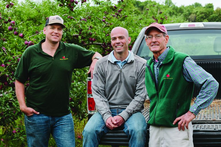 John Rogers and his family smile for a photo in their apple orchard